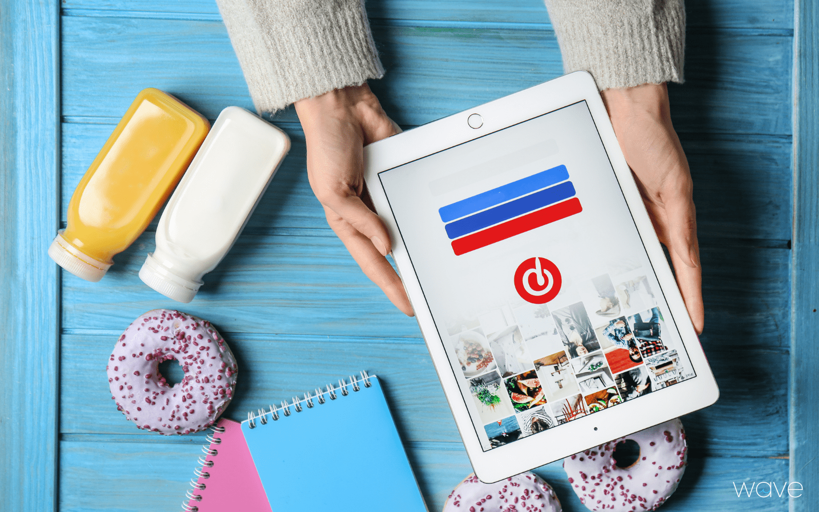 Person holding an ipad logging into pinterest. On the table are drinks and donuts.