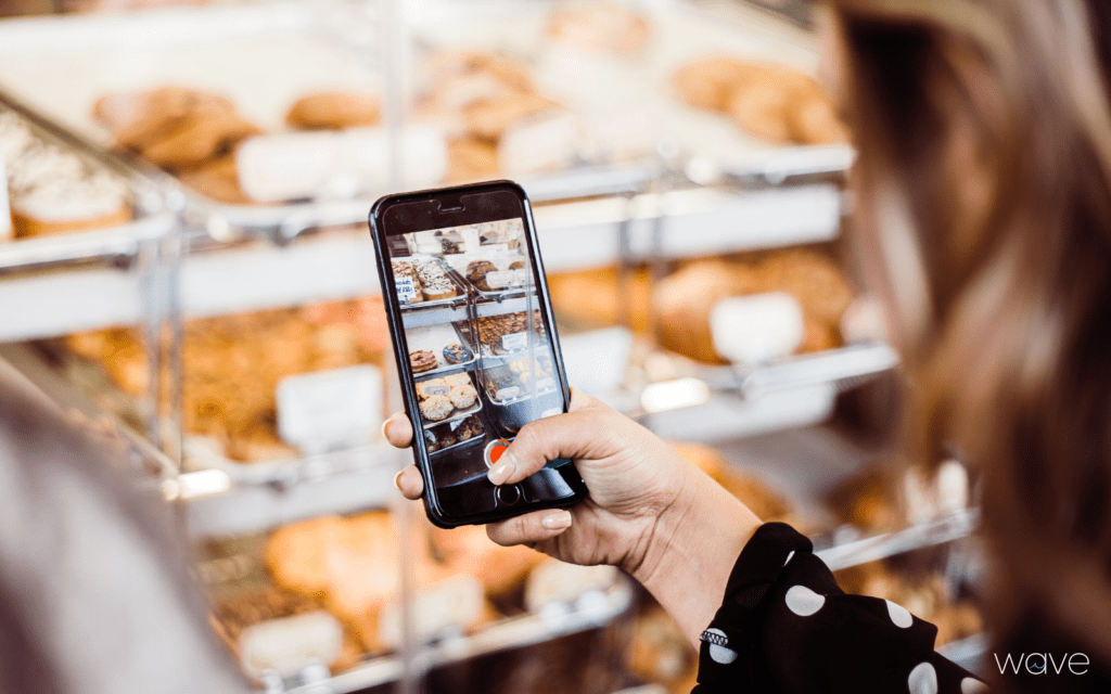 influencer filming on phone at bakery